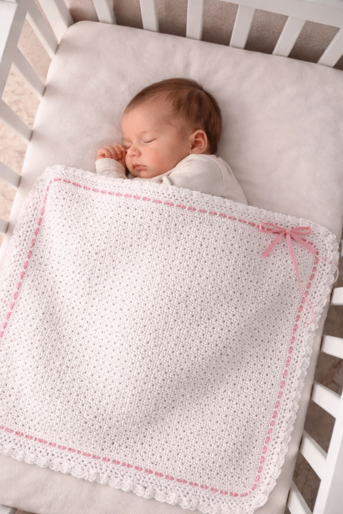 Bebé dormido en cuna blanca